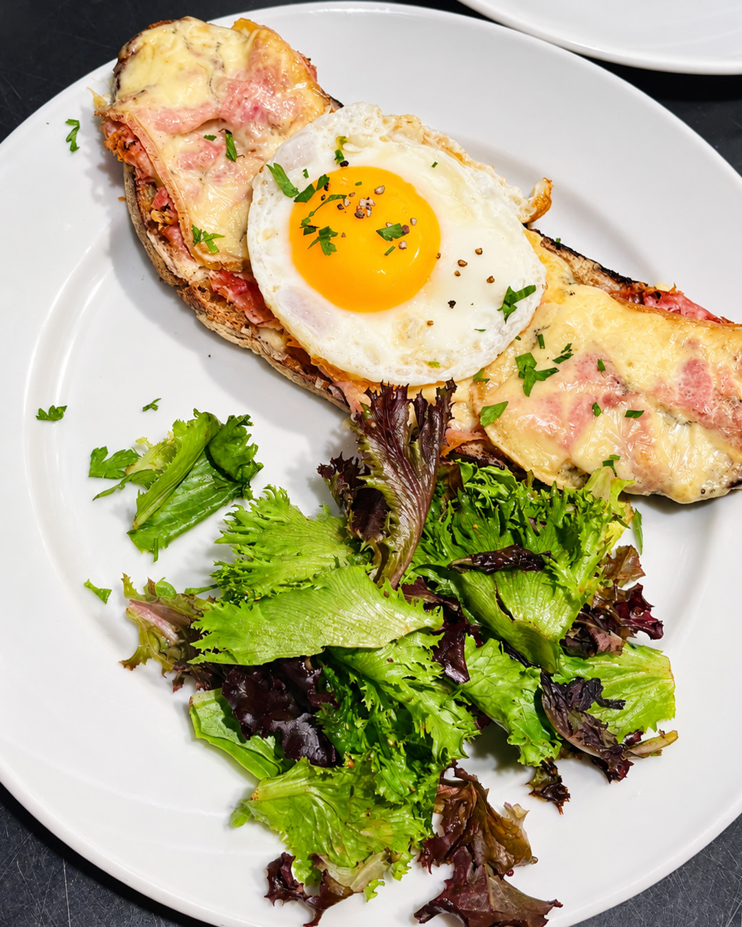 Tartine gratinée à l'œuf accompagnée d'une salade verte